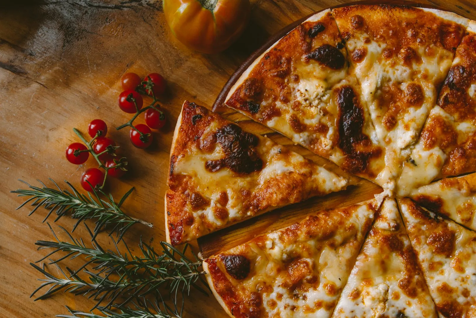 Fresh pepperoni apizza with a charred crust on a wooden table